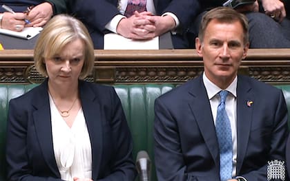 La primera ministra británica, Liz Truss, haciendo una mueca junto al ministro de Hacienda de Gran Bretaña, Jeremy Hunt, mientras el Partido Laborista de la oposición se dirige a ella durante el turno de preguntas de la primera ministra en la Cámara de los Comunes, en Londres, el 19 de octubre de 2022.