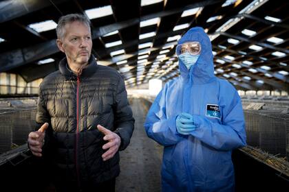 La primera ministra de Dinamarca, Mette Frederiksen (der.), y el criador de visones Peter Hindbo visitan una granja cerrada y vacía cerca de Kolding, Dinamarca, el 26 de noviembre de 2020
