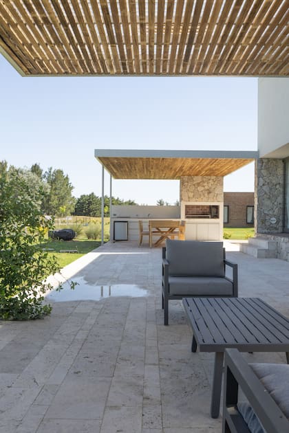 La primera pérgola, hecha con varillas deja pasar la luz sobre el living exterior; la que asiste a la parrilla tiene un cielo raso compacto, para resguardar al parrillero y a los comensales del sol.