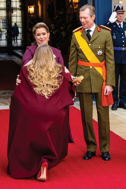 La princesa Amalia se inclina ante María Teresa, la Gran Duquesa saliente. A su lado, su marido, Enrique, con uniforme militar de jefe de los ejércitos