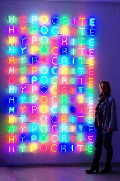 La princesa artista junto a una instalación con luces de neón. La palabra que se lee multiplicada es "hipócrita", como ella suele referirse al poder, especialmente en su país.