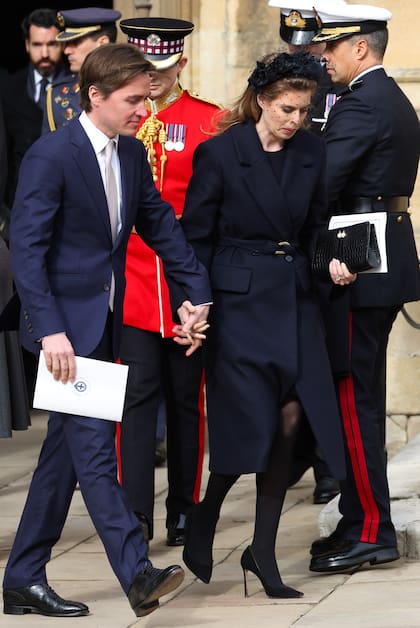 La princesa Beatrice (con tapado Maje, pumps Jimmy Choo y vincha JBH Millinery) y su marido, Edoardo Mapelli Mozzi.