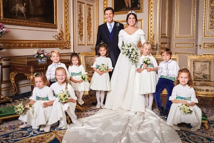 La princesa Eugenia y Jack Brooksbank el día de su boda, el 12 de octubre de 2018, en Windsor. Los acompañan los más chiquitos de la familia real, entre los que están el príncipe George y la princesa Charlotte (hijos de William y Kate de Gales), sentados a la izquierda de la imagen.
