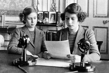La princesa Isabel, de 14 años (a la derecha), aparece con su hermana, la princesa Margarita, antes de dar su primera transmisión de radio en Londres el 13 de octubre de 1940