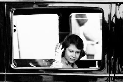 La princesa Isabel, la futura hija mayor del rey, saluda a la multitud que la vio salir del Palacio de Buckingham en Londres, el 4 de junio de 1937