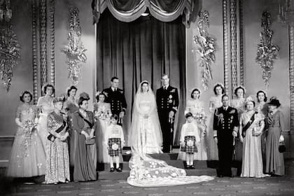 La princesa Isabel y el teniente Felipe Mountbatten con parientes cercanos y damas de honor en el Salón del Trono del Palacio de Buckingham inmediatamente después de la ceremonia nupcial. En la primera fila están (de izq. a der.) la reina María (madre del rey), la princesa Andrés de Grecia (madre del duque de Edimburgo), el difunto príncipe Guillermo de Gloucester con su compañero paje, el príncipe Miguel de Kent, el rey Jorge VI y la reina madre. Fila de atrás; las damas de honor son de izquierda a derecha: la honorable Margaret Elphinstone, la honorable Pamela Mountbatten, Lady Mary Cambridge, SAR la princesa Alejandra de Kent, SAR la princesa Margarita, Lady Caroline Montagu-Douglas-Scott, Lady Elizabeth Lambart y la honorable Diana Bowes-Lyon. (Photo by PA Images via Getty Images)