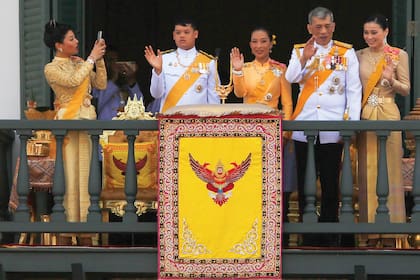 La princesa junto con la familia real tailandesa saluda desde el balcón del Suddhaisavarya Prasad Hall del Gran Palacio, en Bangkok. De izquierda a derecha, Sirivannavari, el príncipe Dipangkorn Rasmijoti, la princesa Bajrakitiyabha (abogada y diplomática, es la hija del primer matrimonio del monarca), el rey Maha Vajiralongkorn y la reina Suthilda.