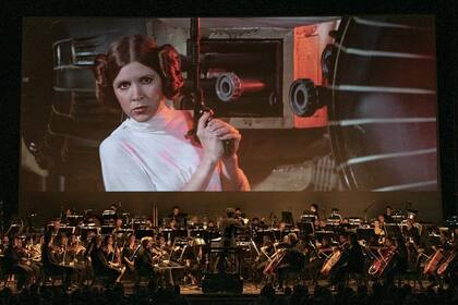 La princesa Leia asoma por la gran pantalla del Teatro Colón, frente a su Orquesta Estable