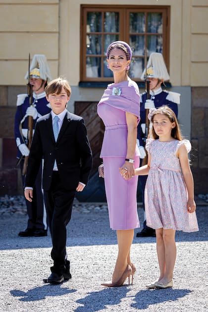 La princesa Magdalena, con un vestido de la firma inglesa Safiyaa, ceñido a la cintura y con falda lápiz; un tocado de diadema con velo de red y pendientes florales. En la foto, con dos de sus tres hijos, Nicolas (10) y Adrienne (7).