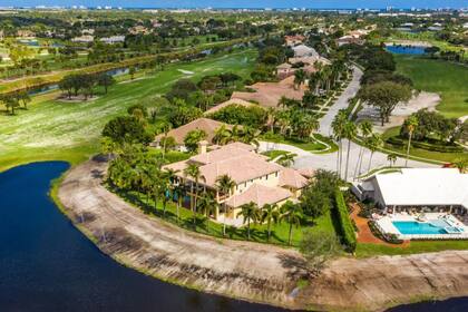 La propiedad ofrece panorámicas de un campo de golf y un lago privado, y destaca por su ubicación en una de las áreas más exclusivas de Boca Raton