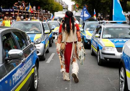 Una persona disfrazada camina entre los autos durante la protesta masiva en la capital alemana