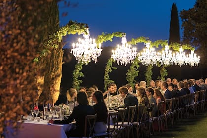 La puesta en escena fue realmente soñada. Rodeados de cipreses iluminados por arañas de caireles, los invitados disfrutaron de un menú a base de quesos de la Toscana, bisteccas y “pici”, pastas típicas de Montepulciano.