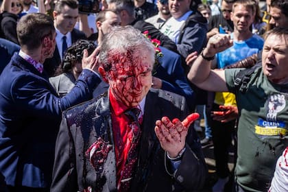 La reacción del embajador Sergei Andreev tras ser atacado con pintura roja (Photo by Wojtek RADWANSKI / AFP)