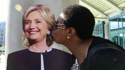 La recién nacionalizada estadounidense Makia Nunes besa una figura de cartón de Hillary Clinton en Los Angeles