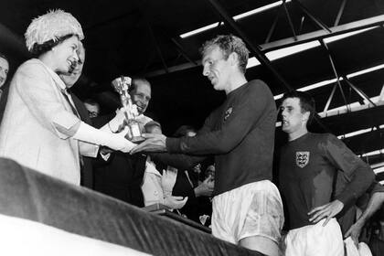 La Reina en un momento sublime para el deporte inglés: Bobby Moore, capitán del seleccionado, recibe la Copa Jules Rimet tras ganar la final en Inglaterra 1966.