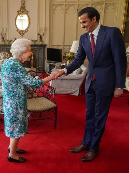 La reina Isabel II de Gran Bretaña le da la mano al emir de Qatar, el jeque Tamim bin Hamad al-Thani, durante una audiencia en el Castillo de Windsor, al oeste de Londres, el 24 de mayo de 2022