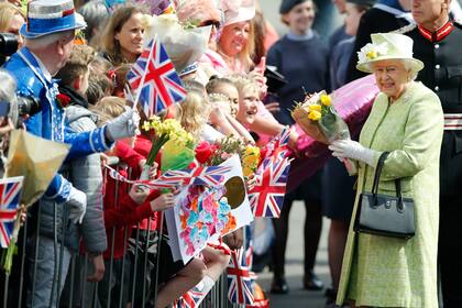 La reina Isabel II de Gran Bretaña recoge flores y buenos deseos durante una caminata para celebrar su 90 cumpleaños en Windsor, Inglaterra, el jueves 21 de abril de 2016