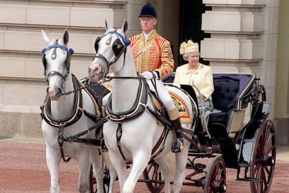 La reina Isabel II sale del Palacio de Buckingham en un carruaje abierto el 14 de junio de 1997 camino al Desfile de la Guardia a Caballo para Trooping the Color. La ceremonia anual se lleva a cabo para celebrar el cumpleaños oficial de la Reina