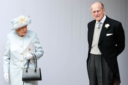 La reina Isabel II y el príncipe Felipe, esperan a que pase el carruaje que transporta a la princesa Eugenia de York y su esposo Jack Brooksbank después de su ceremonia de boda en la Capilla de San Jorge, Castillo de Windsor, el 12 de octubre de 2018