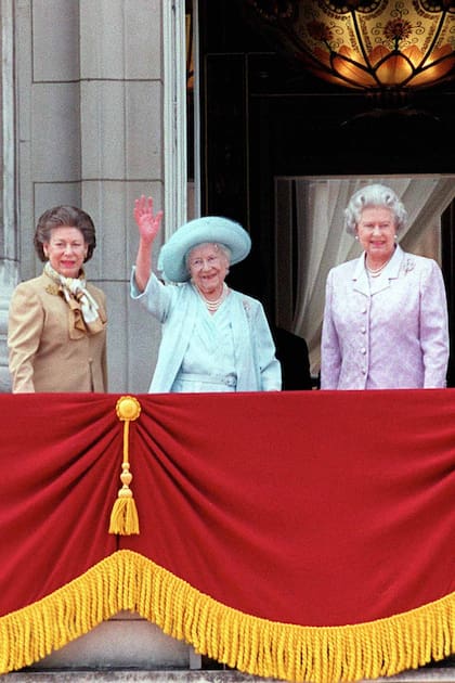 La Reina Madre de Gran Bretaña con sombrero azul y vestido celebrando su 100 cumpleaños con sus hijas: la princesa Margarita en marrón y la Reina Isabel II en lavanda en el Palacio de Buckingham.. (Photo by Ken Goff/Getty Images)