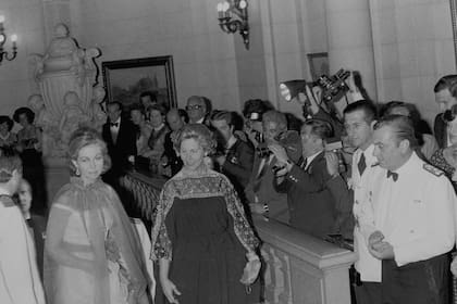 La reina Sofía, con su capa roja, sube las escaleras del Concejo Deliberante junto a Alicia Hartridge, esposa del presidente de facto Jorge R. Videla