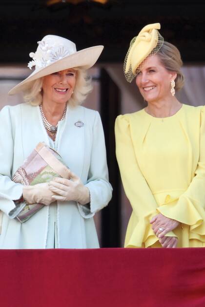 La Reina sonríe junto a la duquesa de Edimburgo. Camilla llevó un vestido y tapado de crêpe de seda de Anna Valentine que acompañó con sombrero de Philip Treacy, mientras que Sophie optó por un vestido de Beulah London y tocado Jane Taylor London. 
