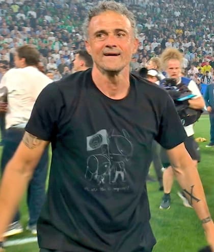 La remera que usó Luis Enrique tras ganar la Champions con el PSG. El dibujo lo muestra a él y a su hija, Xana, clavando la bandera del equipo francés, inspirado en la foto que se sacaron cuando ganó el mismo trofeo con el Barcelona en 2015