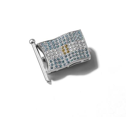 La réplica del broche de Eva Perón, por Testorelli para el Bicentenario. La idolatrada es de oro blanco 18k, tiene topacios azules Sky, citrinos en el sol y diamantes blancos.