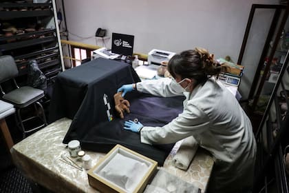 La restauradora de arte Carla Medina trabaja en una pieza precolombina repatriada, en un estudio del Instituto Colombiano de Antropología e Historia en el Museo Nacional, en Bogotá