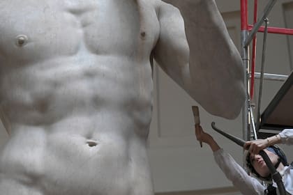 La restauradora italiana Eleonora Pucci limpia la estatua del David de Miguel Ángel usando una aspiradora de mochila y un cepillo de fibra sintética.