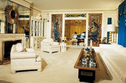 La sala de estar de Graceland, decorada con cortinas doradas y motivos de pavo real