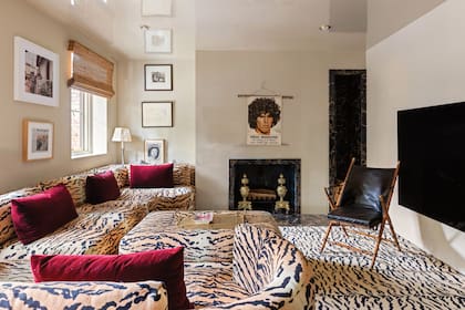La sala de estar, decorada en animal print,
tiene un hogar sobre el que se ve un póster
con la cara de Diego Maradona. El espacio
da acceso a un patio trasero que cuenta con
sauna finlandés y pileta