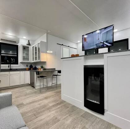 La sala de estar tiene un sofá y una televisión que está encima de un mueble para guardar ropa