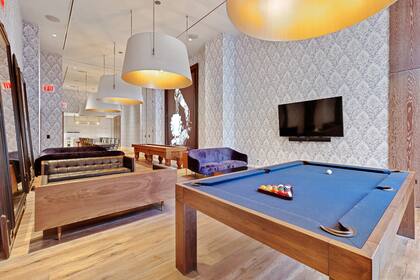 La sala de juegos con mesa de pool y billar es uno de los espacios comunes del edificio
