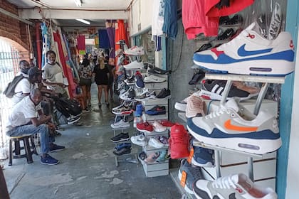 Puestos de venta de calzado, con vendedores a la espera, en uno de los paseos de compras que componen La Salada