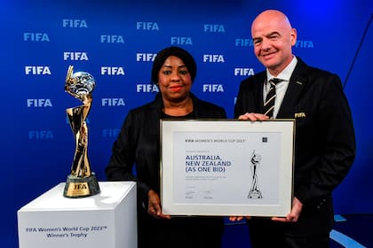 La secretaria general de la FIFA, Fatma Samoura (izq.) Y el presidente de la FIFA, Gianni Infantino, posan junto al Trofeo de la Copa Mundial Femenina después del anuncio de que Australia / Nueva Zelanda son los anfitriones ganadores de la Copa Mundial Femenina de la FIFA 2023