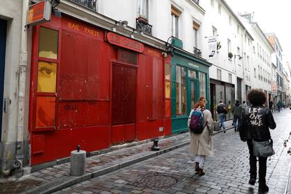 La gente pasa por un bar cerrado, como parte de las restricciones más estrictas debido al brote de la enfermedad del coronavirus (COVID-19) en París, Francia