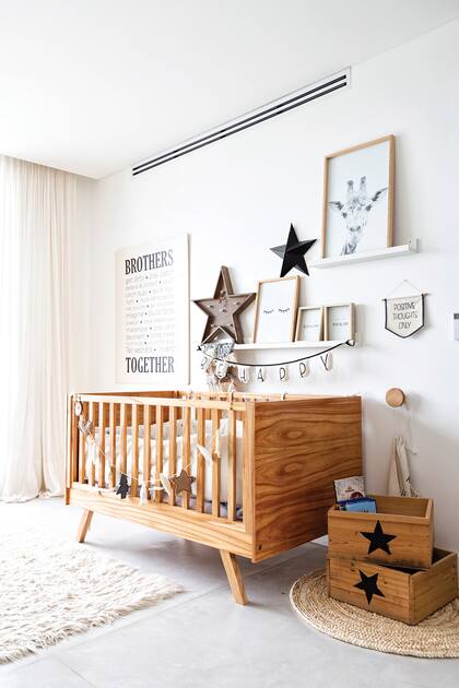 La sencillez reina en el cuarto del bebe, con detalles en madera y gris en sintonía con el resto de la casa. El detalles, las estrellas iluminadas