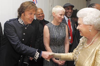La soberana saluda a Paul Mc Cartney –detrás se ve a Annie Lennox– después del concierto por el 60° aniversario de su ascensión al trono. En 1965, la Reina había distinguido a The Beatles como de la Orden del Imperio Británico.