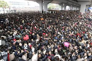 La sobrepoblación de algunas zonas urbanas plantea importantes restos y problemas para China, como evidencia esta imagen de pasajeros tratando de ingresar a la estación de trenes de Cantón