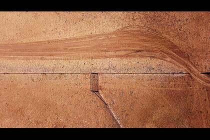 La sombra de una puerta junto a las huellas de automóviles en la propiedad de Jimmie y May McKeown ubicada en las afueras de la ciudad de Walgett en Nueva Gales del Sur