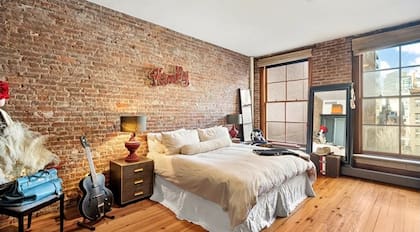 La suite principal incluye un vestidor, baño estilo spa con bañera y ducha, y mantiene la estética industrial