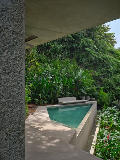 La superficie edificada suma 125 m², de los cuales casi la mitad pertenecen a la terraza y la pileta. El banco de hormigón es un diseño de Formafatal.