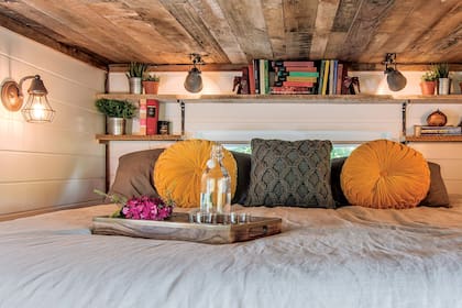 Detrás de la cama, una ventana deja entrar la luz natural y ayuda a ampliar el campo visual.