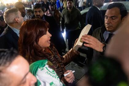 La vicepresidenta Cristina Kirchner, mientras firma autógrafos a la salida de su casa en Recoleta