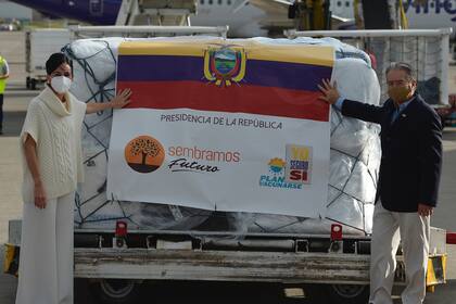 La vicepresidenta de Ecuador, María Alejandra Muñoz, y el ministro de Salud, Juan Carlos Zevallos, posan con un contenedor con las primeras 8000 dosis de la vacuna Pfizer/BioNTech a su llegada al Aeropuerto Internacional Mariscal Sucre de Quito, el 21 de enero de 2021