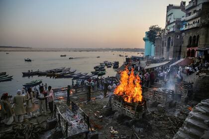 Piras funerarias arden en Manikarnika Ghat, uno de los lugares más antiguos y sagrados para que los hindúes sean incinerados, a orillas del río Ganges en Varanasi