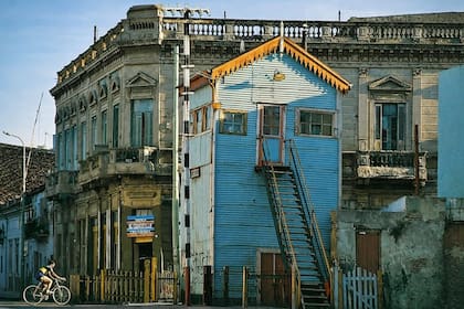 La vieja cabina de empalme de la estación Brown, en la esquina de Garibaldi y Olavarría, a 200 metros de la Bombonera. A la izquierda, un ciclista con la camiseta de Boca.