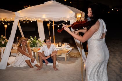 La violinista Hany amenizó la velada mientras los invitados disfrutaban de la cálida noche en la playa.