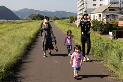 La violinista japonesa Manami Ito camina con su esposo Yuki  y sus dos hijas Miu y Mei cerca de su hogar en Shizuoka